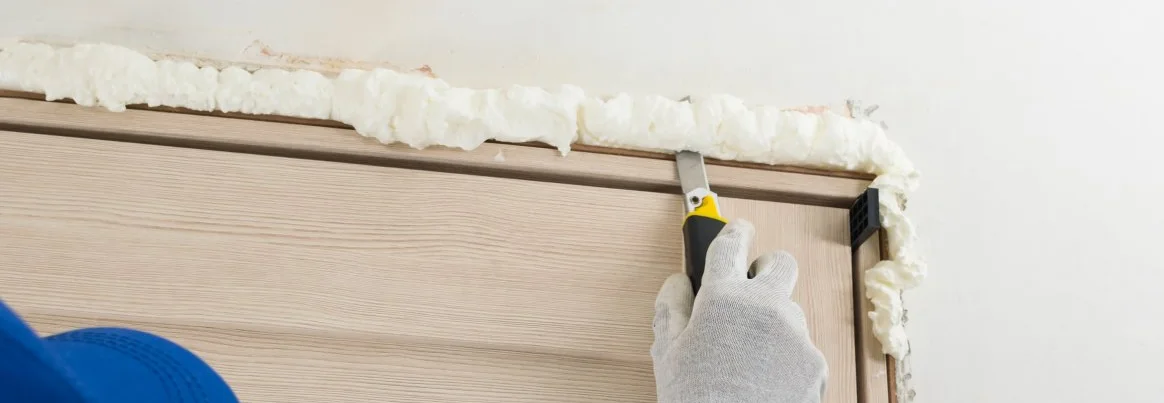 Entfernen von unnötigem getrocknetem Befestigungsschaum aus dem Türschlitz.